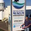 Greg Mellen holds the burgee outside the Whale Museum at Eden