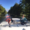 Anne Smith with the burgee driving a canal boat in Burgundy, France.